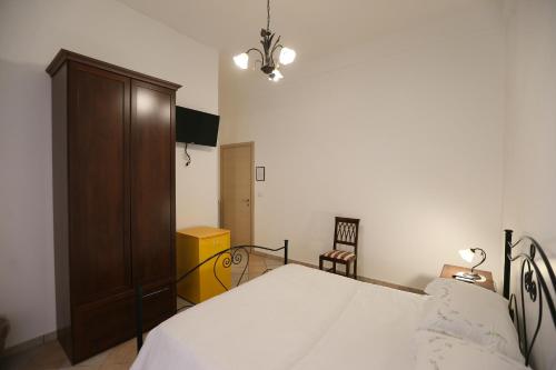 a bedroom with a bed and a wooden cabinet at A Casa Di Silvia B&B in Sannicola