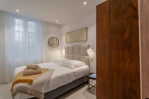 une chambre avec un grand lit avec des draps blancs dans l'établissement Le Balcon du Vieux-Port, à Marseille