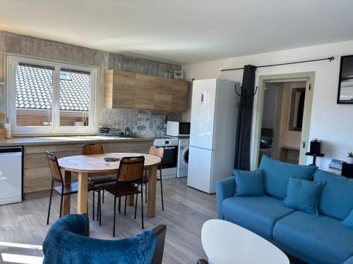 un salon avec un canapé bleu et une table dans l'établissement Le Pin I T2, à Passy