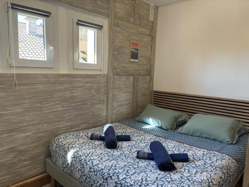 - une chambre avec 2 lits et des chaussons bleus dans l'établissement Le Pin I T2, à Passy