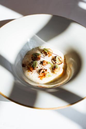 a bowl of food on a plate with a spoon at Boutique Hotel Azur in De Haan