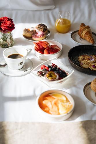 a table topped with cups of coffee and plates of breakfast foods at Boutique Hotel Azur in De Haan