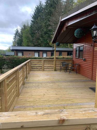 a wooden deck on the side of a house at The Woodhouse Cabin 8 in Moffat