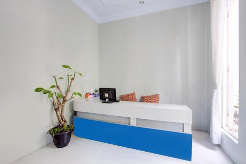 a white and blue desk in a room with a window at Hotel O D'draman Homestay Syariah in Wanujoyo