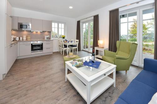 a kitchen and living room with a table and chairs at Ferienwohnung Blaues Haus App 1 in Ralswiek in Ralswiek