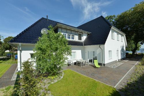 a white house with a black roof at Ferienwohnung Blaues Haus App 1 in Ralswiek in Ralswiek