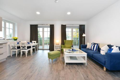 a living room with a blue couch and a table at Ferienwohnung Blaues Haus App 1 in Ralswiek in Ralswiek