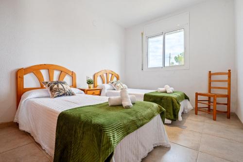 a bedroom with two beds and a window at Villa Flor in Les tres Cales