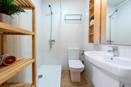 a bathroom with a white toilet and a sink at Loft Sant Joan in L'Ametlla de Mar