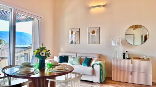 a living room with a couch and a table at Brighter Days - Two-room apartment with lake view and pool in Predore