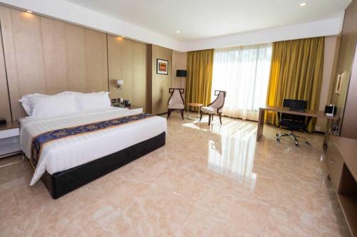 a large hotel room with a bed and a desk at Sunday Hevea Hotel and Resort in Angeles