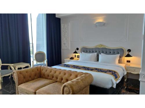 a bedroom with a large bed and a couch at Sunday Hevea Hotel and Resort in Angeles
