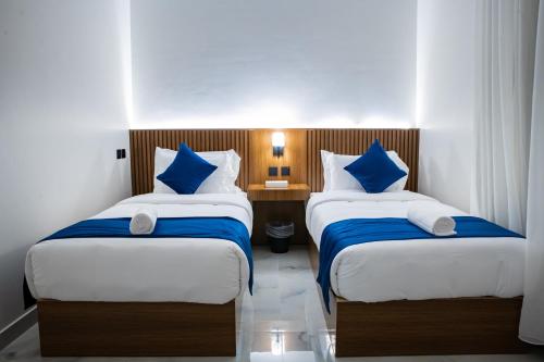 a bedroom with two beds with blue and white pillows at فندق فجر الواحة in Riyadh