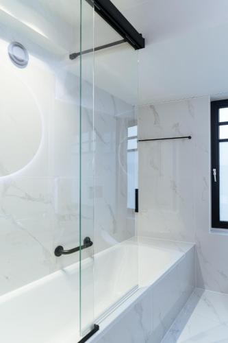 a glass shower with a tub in a bathroom at Boutique Hotel Azur in De Haan