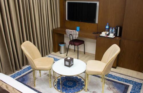 a hotel room with a table and chairs and a television at Blue Moon Hotel in Erbil