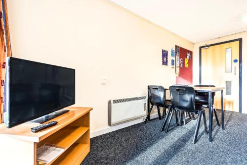 a room with three chairs and a flat screen tv at Crewe City Centre in Crewe