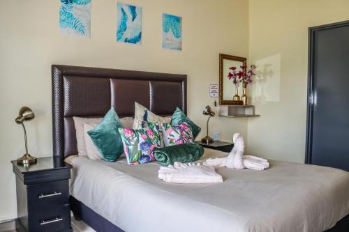 a bedroom with a large bed with colorful pillows at Panorama Chalets & Rest Camp in Graskop