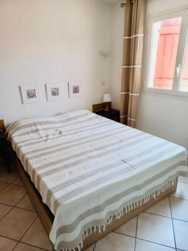 Cette chambre blanche dispose d'un grand lit et d'une fenêtre. dans l'établissement Appartement 221 - LES SUITES DE ROBINSON - Résidence avec piscine en bord de Siagne, à Mandelieu-La-Napoule, à Mandelieu-la-Napoule
