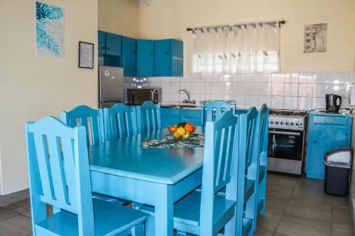 a blue kitchen with a blue table and chairs at Panorama Chalets & Rest Camp in Graskop