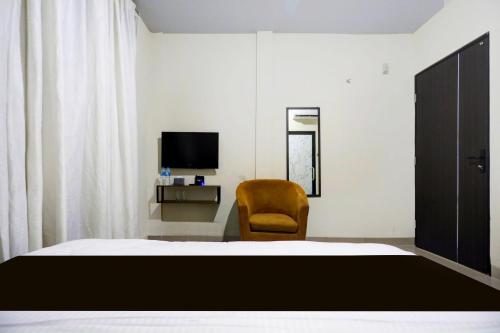 a bedroom with a bed and a chair and a television at Collection O Waterfront City Near Unrika Formerly Dory Inn in Sagulung