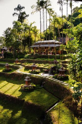 a garden with a building in the middle of it at บ่อเกลือ วิว รีสอร์ท in Ban Pha Khap