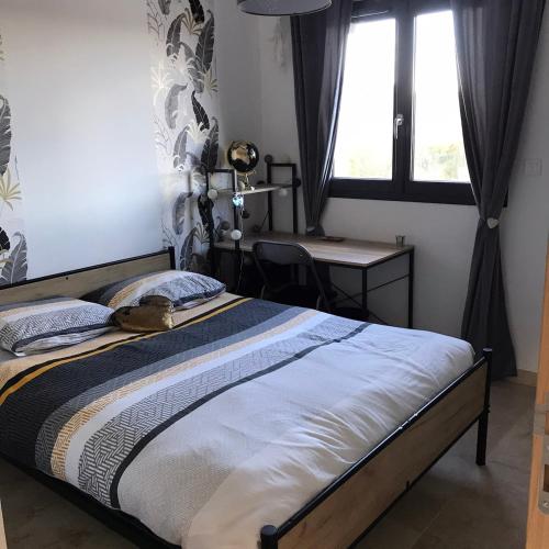 - une chambre avec un lit, un bureau et une fenêtre dans l'établissement Villa soleil, à Bagard