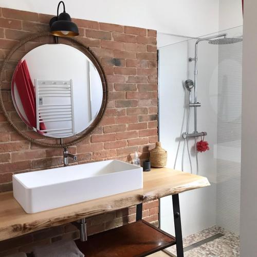 une salle de bain avec un lavabo blanc et un miroir dans l'établissement Villa soleil, à Bagard
