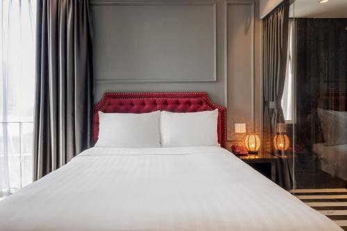 a bedroom with a large bed with a red headboard at Collection O Le Grand Hanoi hotel - The Sun in Hanoi