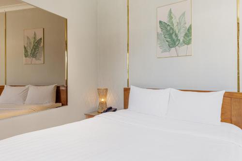a bedroom with a white bed and a mirror at Collection O Le Grand Hanoi hotel - The Sun in Hanoi