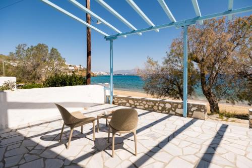 a patio with two chairs and a table and a view of the ocean at Afroditi studios in Logaras