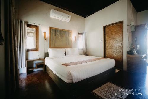 a bedroom with a large white bed in a room at บ่อเกลือ วิว รีสอร์ท in Ban Pha Khap