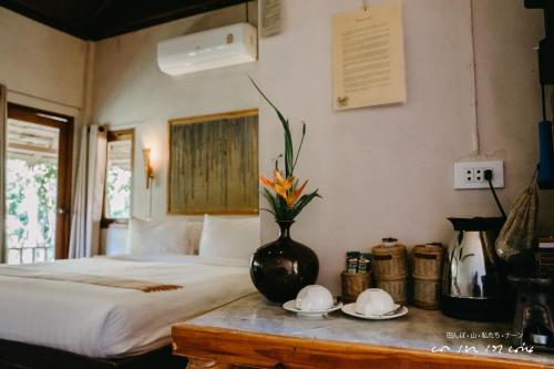 a bedroom with a bed and a vase on a table at บ่อเกลือ วิว รีสอร์ท in Ban Pha Khap