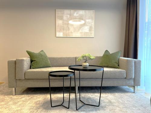 a living room with a couch and two tables at Free Parking - City Pulse Apartments at U6-Metro Vienna in Vienna