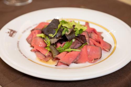 a white plate of food on a table at Hotel Stendhal in Parma