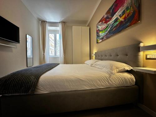 Un dormitorio con una cama con un cuadro en la pared. en Suite della Marchesa, en Génova