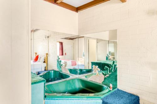 a bathroom with a green tub in a room at OYO Oasis Motel Las Vegas I-15 in Las Vegas