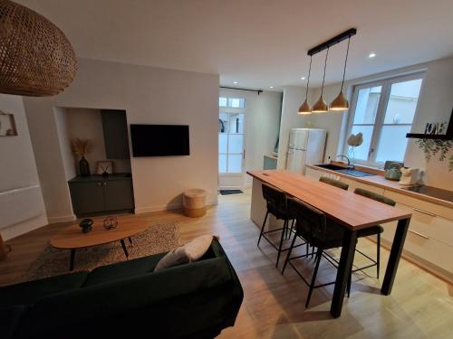 une cuisine et un salon avec une table et un canapé dans l'établissement Elegance Showroom - Appartement en Hyper Centre, à Bourges