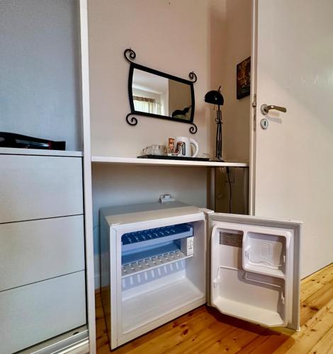 a small refrigerator with its door open in a kitchen at Mary's Guesthouse in Banya