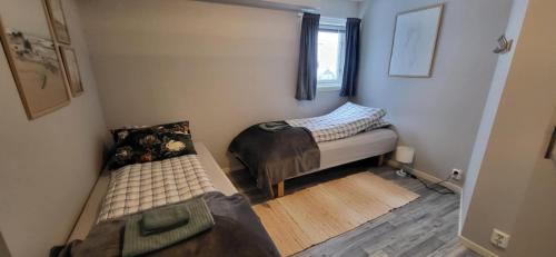 a small room with two beds and a window at Perfect apartment for whale safari at Skjervøy! in Skjervøy