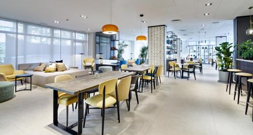 a restaurant with tables and chairs and a couch at Sercotel Madrid Aeropuerto in Madrid