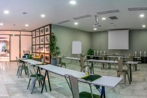a classroom with tables and chairs in a room at Sercotel Madrid Aeropuerto in Madrid