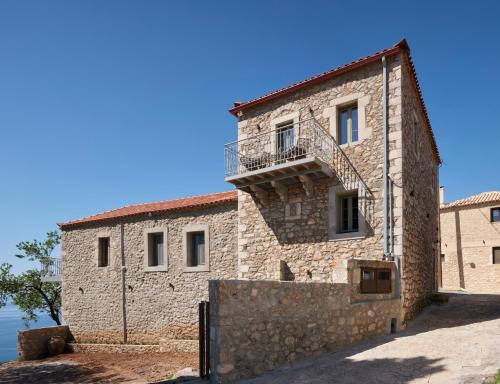 an external view of a stone building with a balcony at Rubeas Towers - Pyrgos Towers Complex in Pírgos