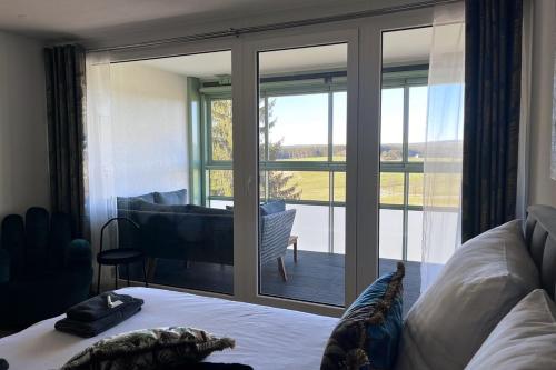 a bedroom with a bed and a sliding glass door at Apartment mit Grüner Aussicht im Schwarzwald in Löffingen