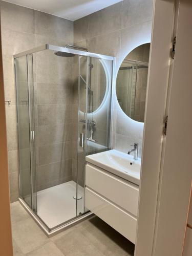 a bathroom with a shower and a sink and a mirror at Apartament Julia 1-4 os Starowapiennikowa 42a z balkonem, klimatyzacją i miejscem parkingowym in Kielce