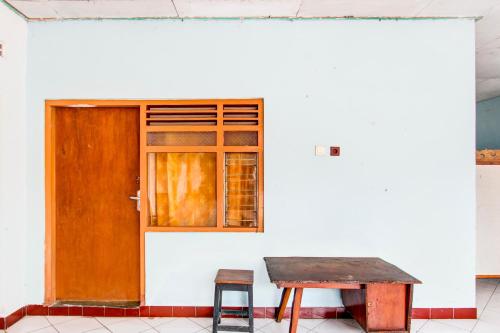 a wooden door and a table and a stool at Hotel O Joglo Menoreh Resto & Homestay in Yogyakarta
