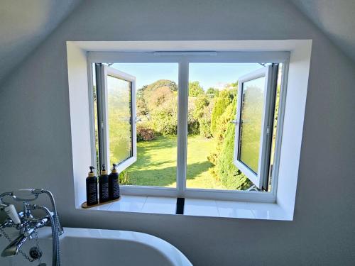 a window in a bathroom with a tub and a view at The Glen in Hythe