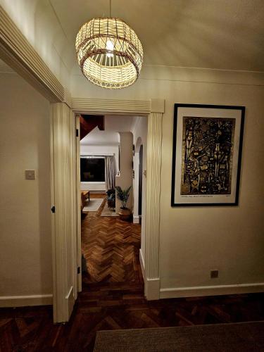 a hallway with a large chandelier and a living room at The Glen in Hythe