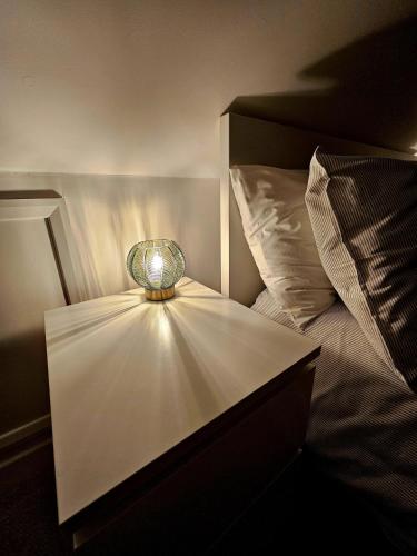 a lamp sitting on a table next to a bed at The Glen in Hythe