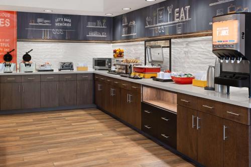 a restaurant kitchen with wooden cabinets and a counter top at Hampton Inn Cleveland-Airport/Tiedeman Road in Brooklyn