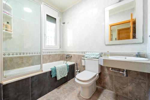 a bathroom with a toilet and a sink and a tub at La Moreneta in Miami Platja